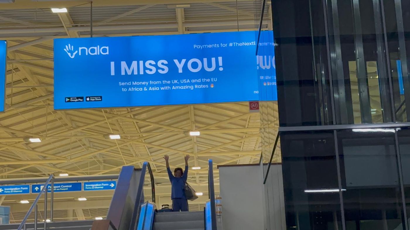 Dee leaving Africa beneath an I MISS YOU sign